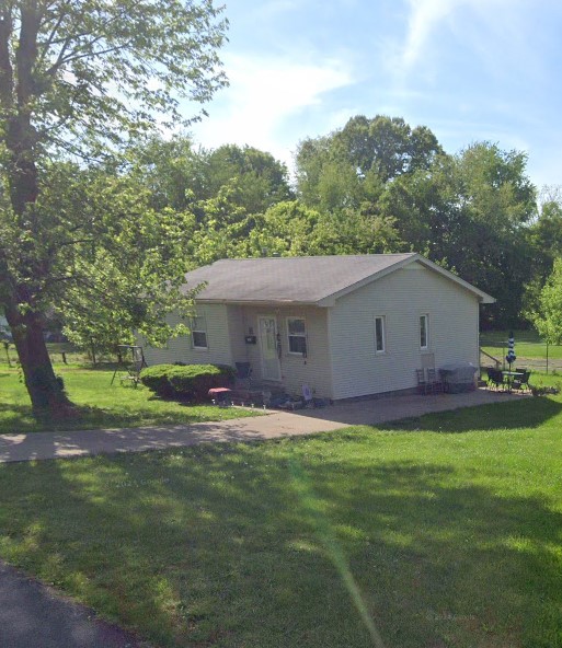 Picture of a tan house from the road